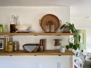 How to organize a small kitchen without a pantry includes stocking open shelves like the ones shown here.