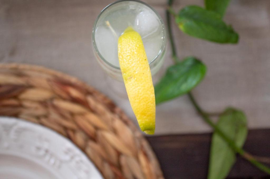 Drinking glasses serve guests the finest fresh lemonade with a lemon garnish.