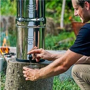 A man gets water out of his water filter.