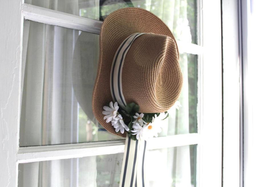 A DIY summer wreath is hung on an exterior side door of a cottage.