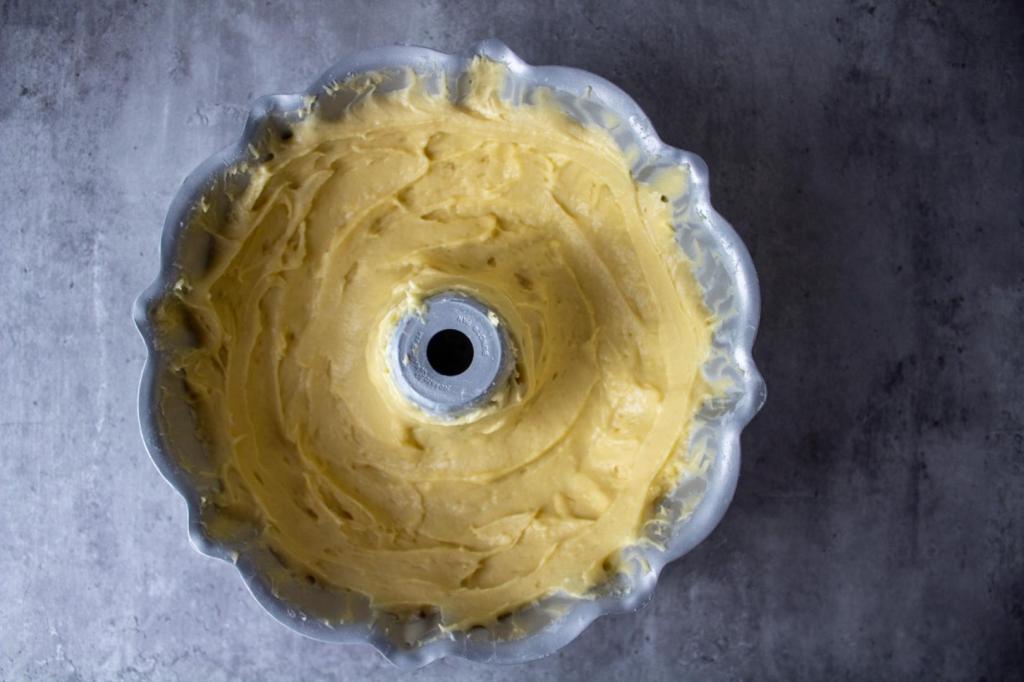 Cake batter is added to a bundt cake pan.