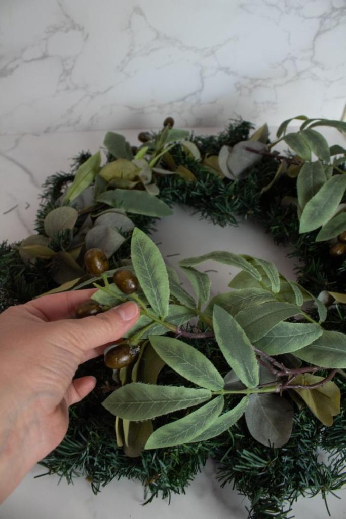 Olive branches are added to a eucalyptus wreath.