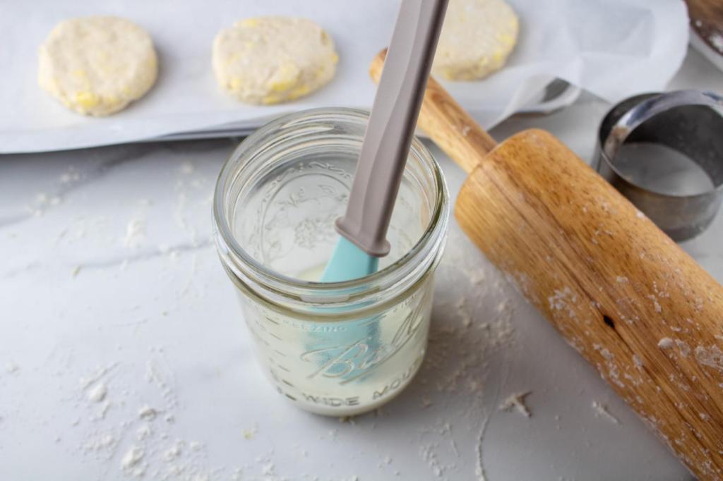 A jar of milk sits with a pastry brush in it.
