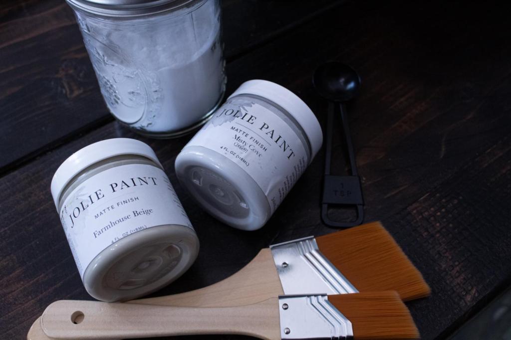 Baking soda, paint brushes, and paints lay on a table.