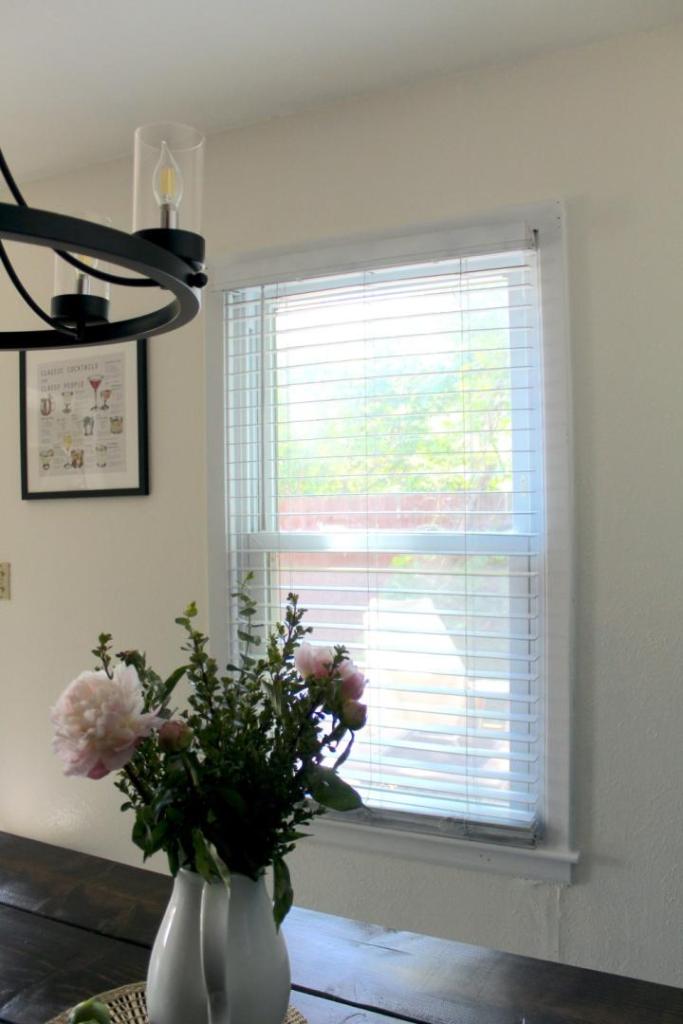 A white kitchen now features white painted window blinds after learning how to paint window blinds.