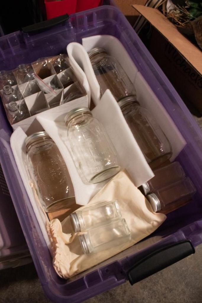 Kitchen jars and extra equipment are stored in a purple bin for safekeeping.