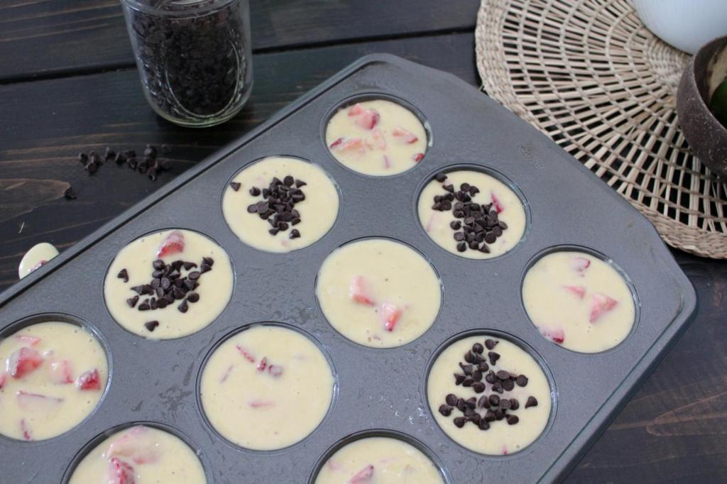 Chocolate chips have been added to some strawberry muffins before baking.