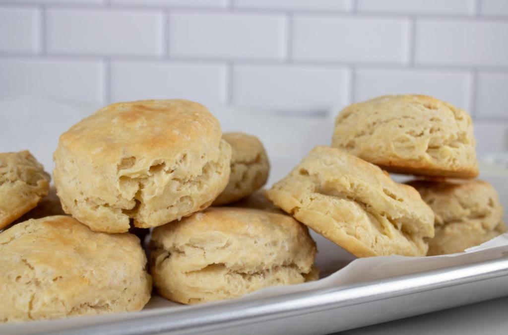 Easy fluffy biscuits are piled on top of a cookie sheet.
