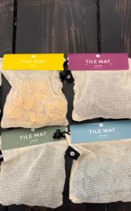 Colored tiles arrive in mesh bags and are laid on a table.