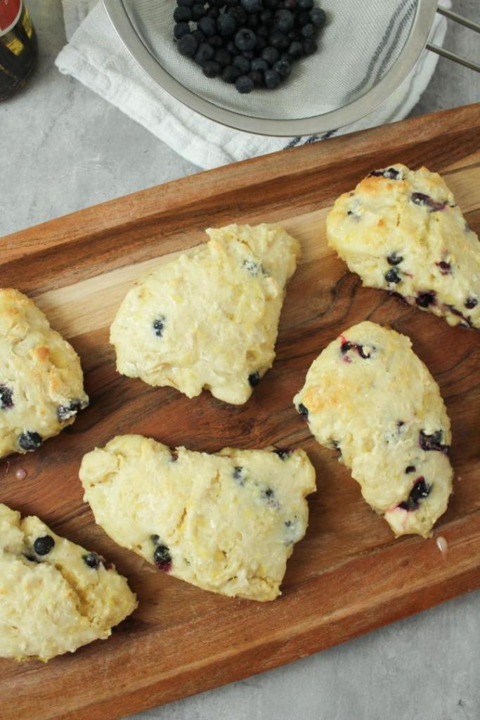 Scones are all laid out on a tray to be devoured.