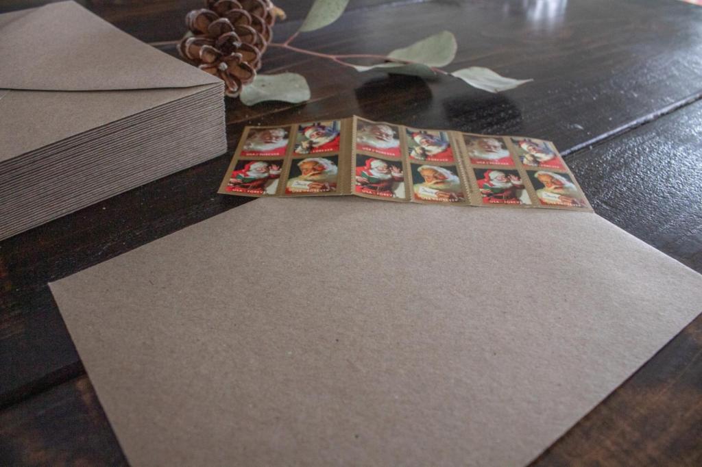 A Kraft envelope and stamps are the first part of Christmas card envelope decorating ideas.