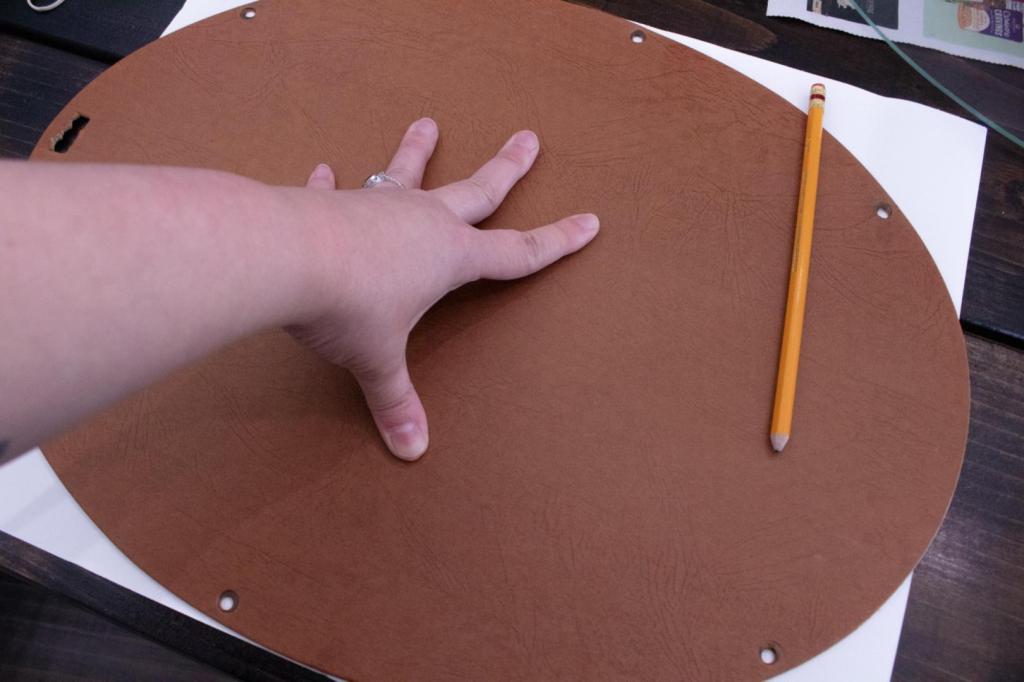 An art print it being traced for trimming down to fit an oval picture frame.