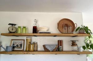 Kitchen floating shelves show decor and practical kitchen items in a cottage kitchen.