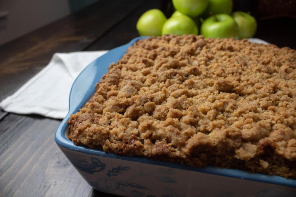 A fall apple cake is fresh from the oven and has Granny Smith apples behind it.