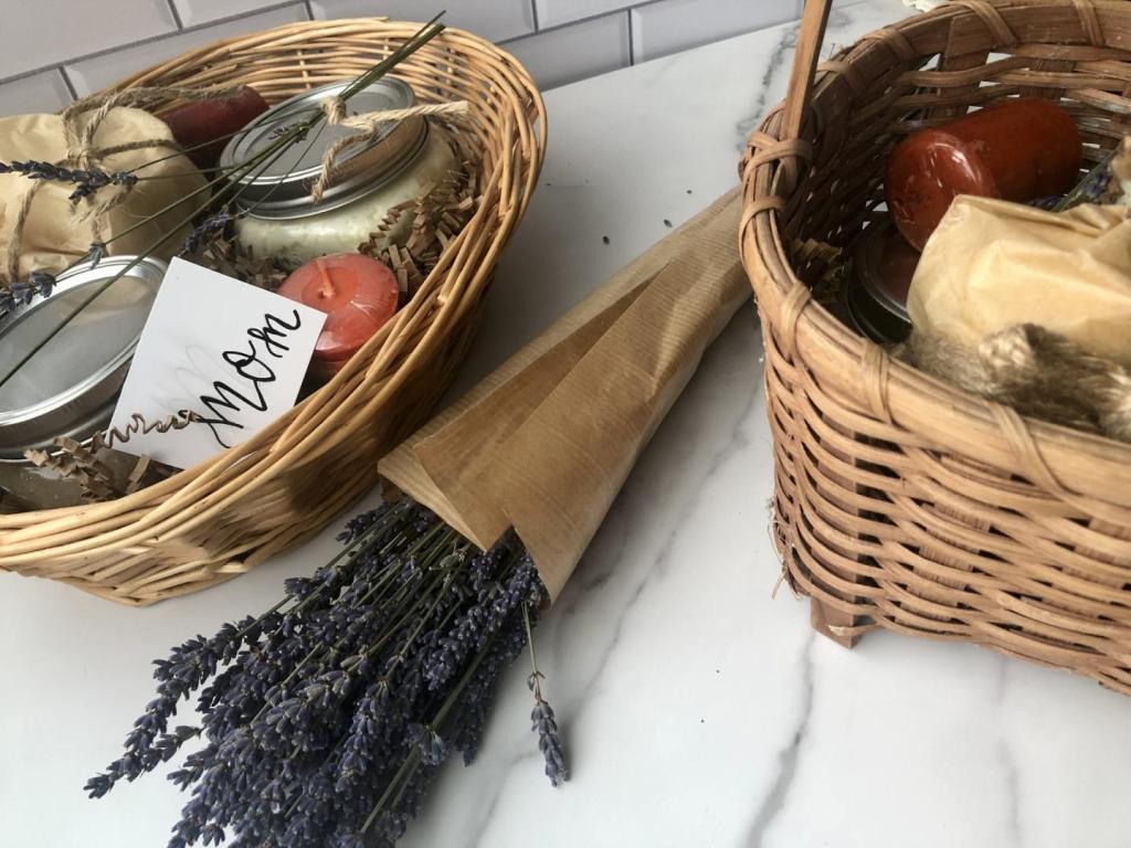 A bouquet of fresh lavender is bundled next to gift baskets.