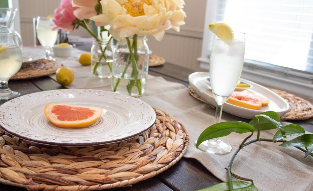 Placemats and a table runner are layered into a summer tablescape.