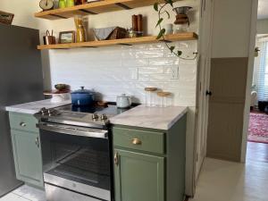 DIY subway tile backsplash is shown above a slide-in range and lower cabinets.