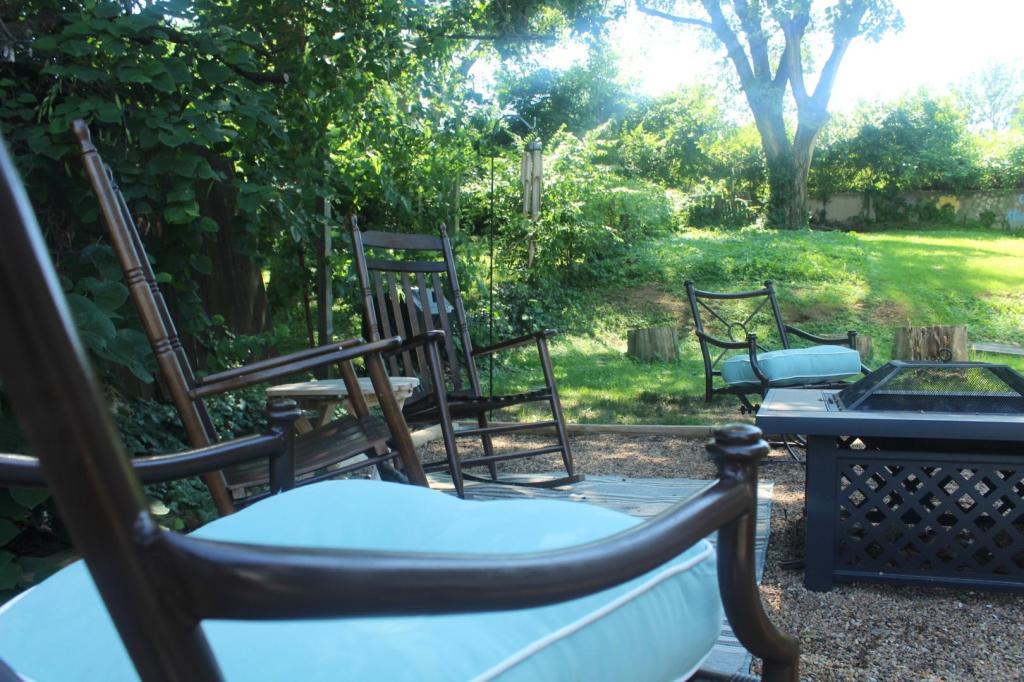 Two metal patio chairs have been makeover and shine on a pea gravel patio with walnut rocking chairs.