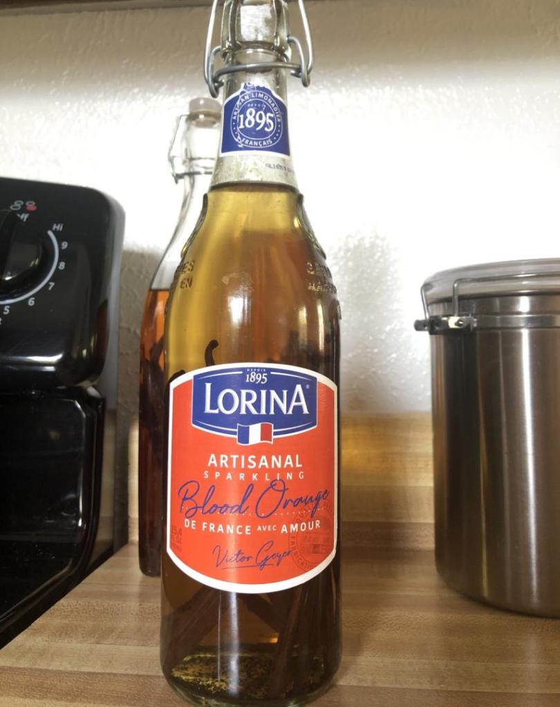 A home-brewed vanilla extract is stored inside a reused glass bottle.