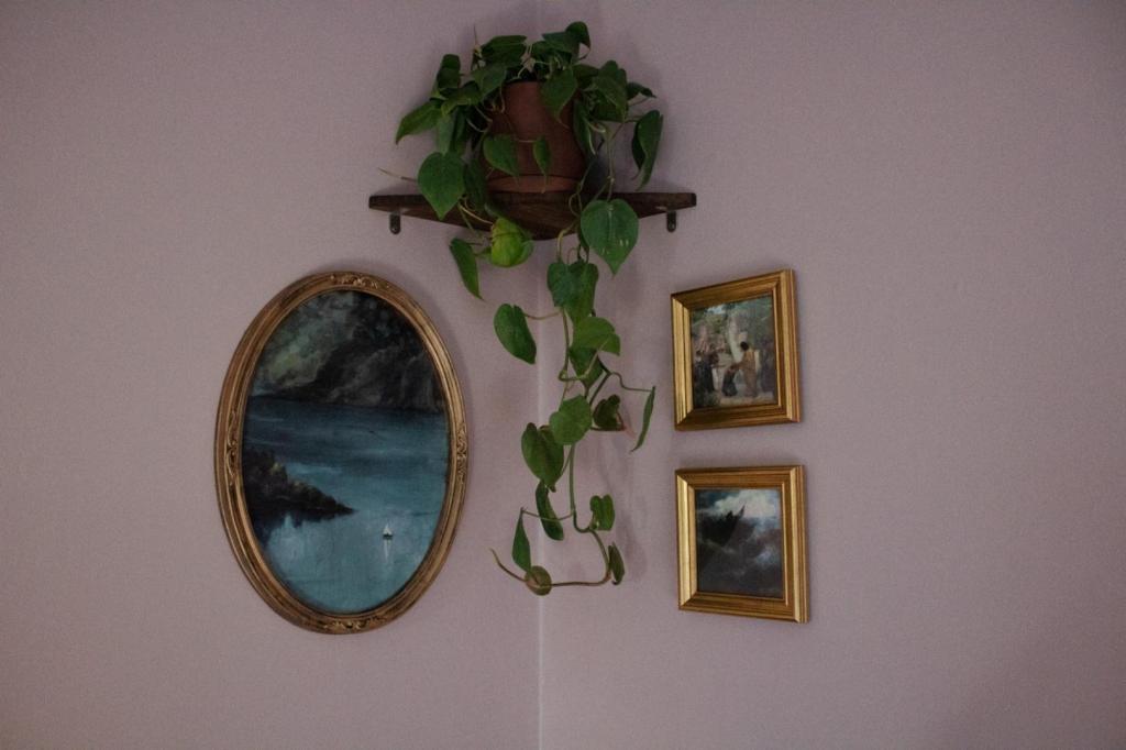 A cozy corner nook has art displayed on the walls of this cottagecore bedroom.