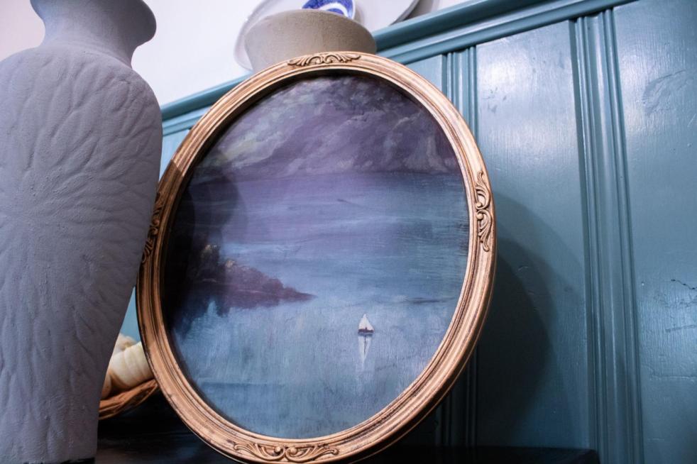 An picture frame has been made over using Antique Gold Rub 'n Buff.