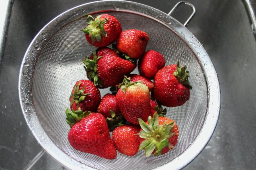 Strawberries are being washed before eaten.