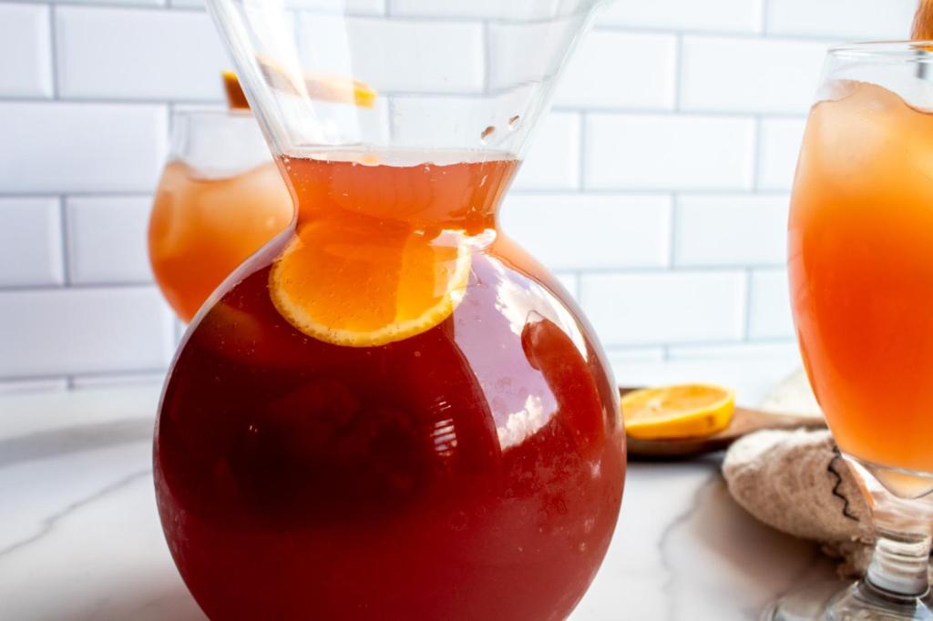 Vibrant virgin sangria mocktail is pictured in a glass carafe.