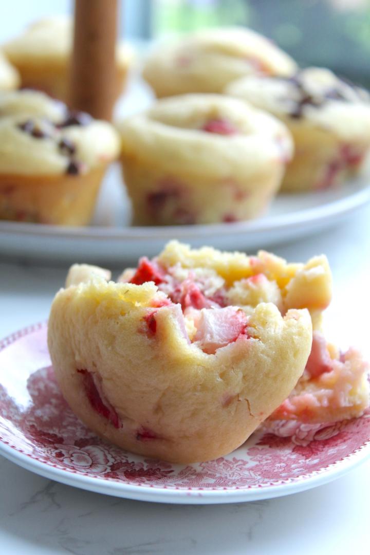 This easy muffin recipe consists of strawberry muffins that are sitting on a tiered platter on a marble countertop.
