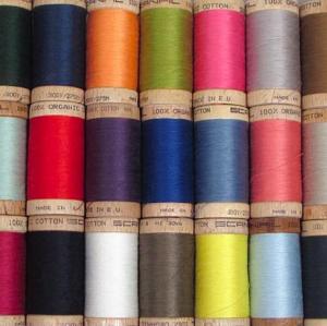 Many colored spools of thread are pictured.