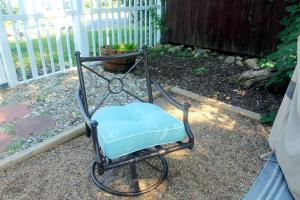 A patio chair is ready for use on its patio.