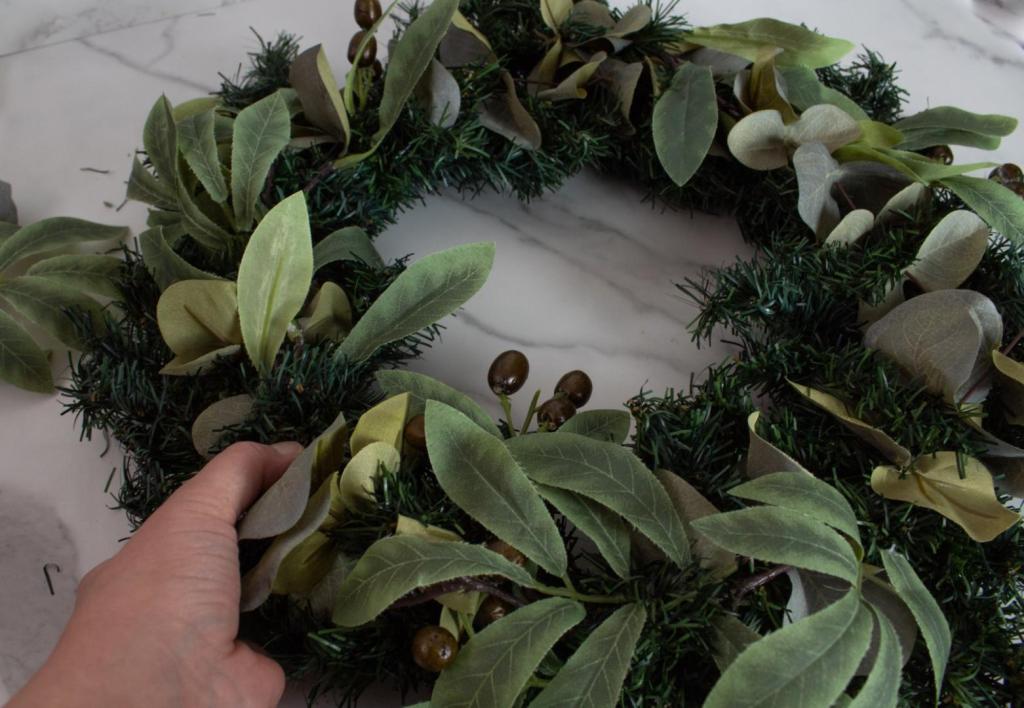 Olives stand out on a large eucalyptus Christmas wreath.