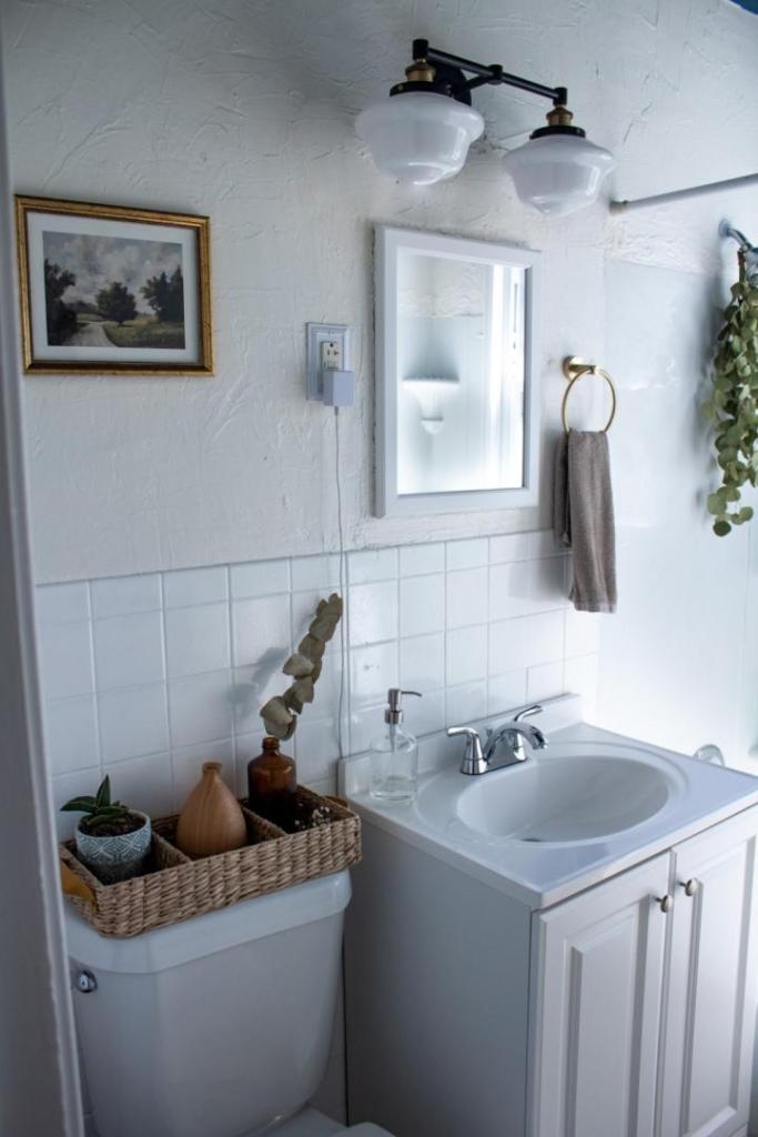 A new bathroom makeover has new hardware, art, and vanity lights.