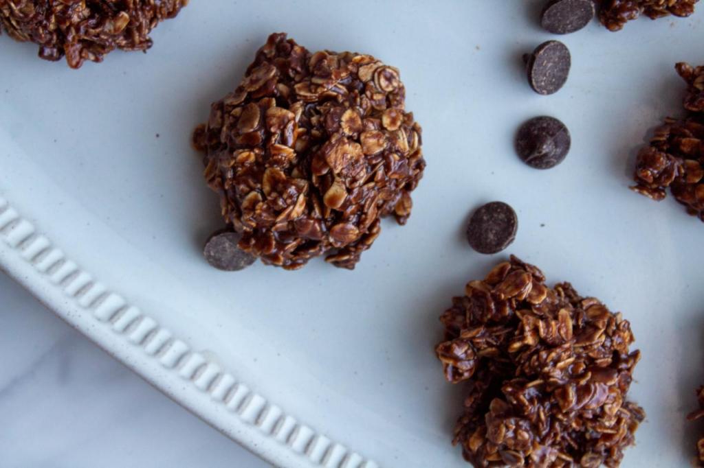 Chocolate oatmeal no bake cookies without peanut butter are scattered with chocolate chips.
