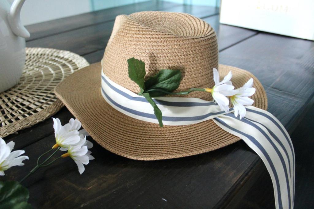 A flower stem has been glued to a hat.