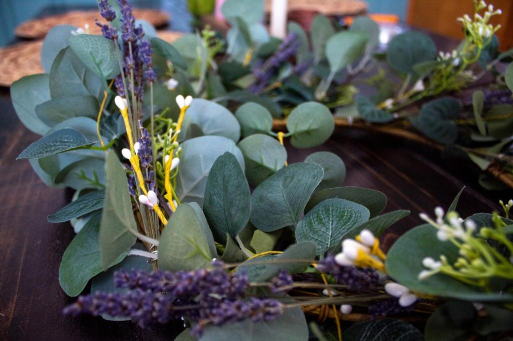 A wreath with lavender and eucalyptus lays out on a table.