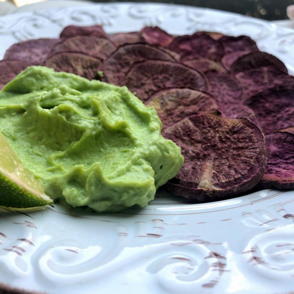 Mashed avocado and greek yogurt dip garnished with a lime and served with roasted purple sweet potatoes. This makes a luscious, creamy avocado dip.