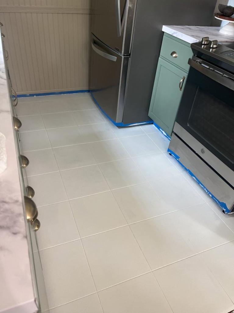 Two layers of white paint are added to kitchen floors.