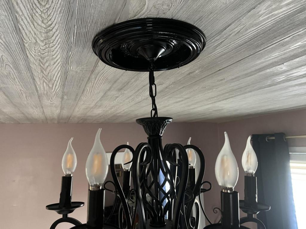 A DIY ceiling medallion is shown on a grey wash ceiling above a chandelier.