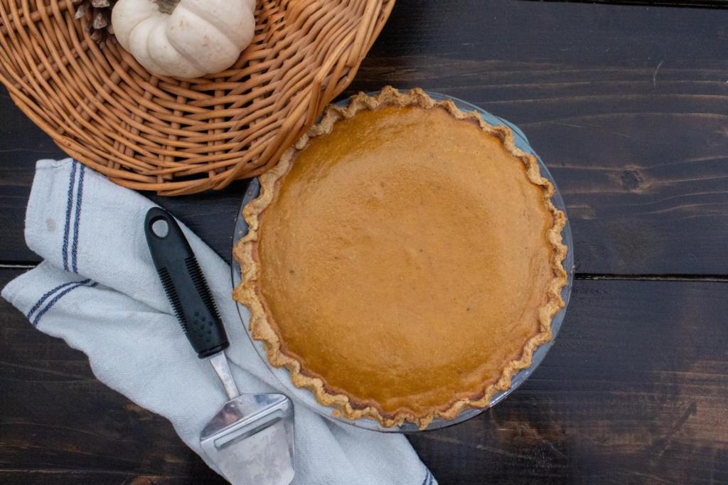 Pie crust tips are shown with a pumpkin pie on a table next to white mini pumpkins.
