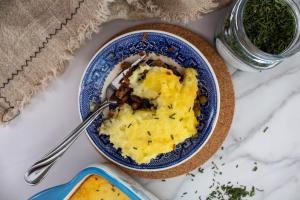 Shepherd's pie has an entire spread laid out with chives, linens, and the cottage pie itself.