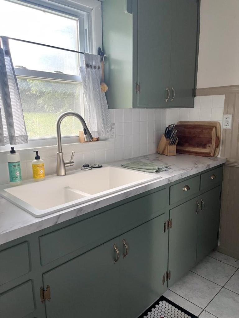 A country kitchen has had old cabinets painted without sanding them first.
