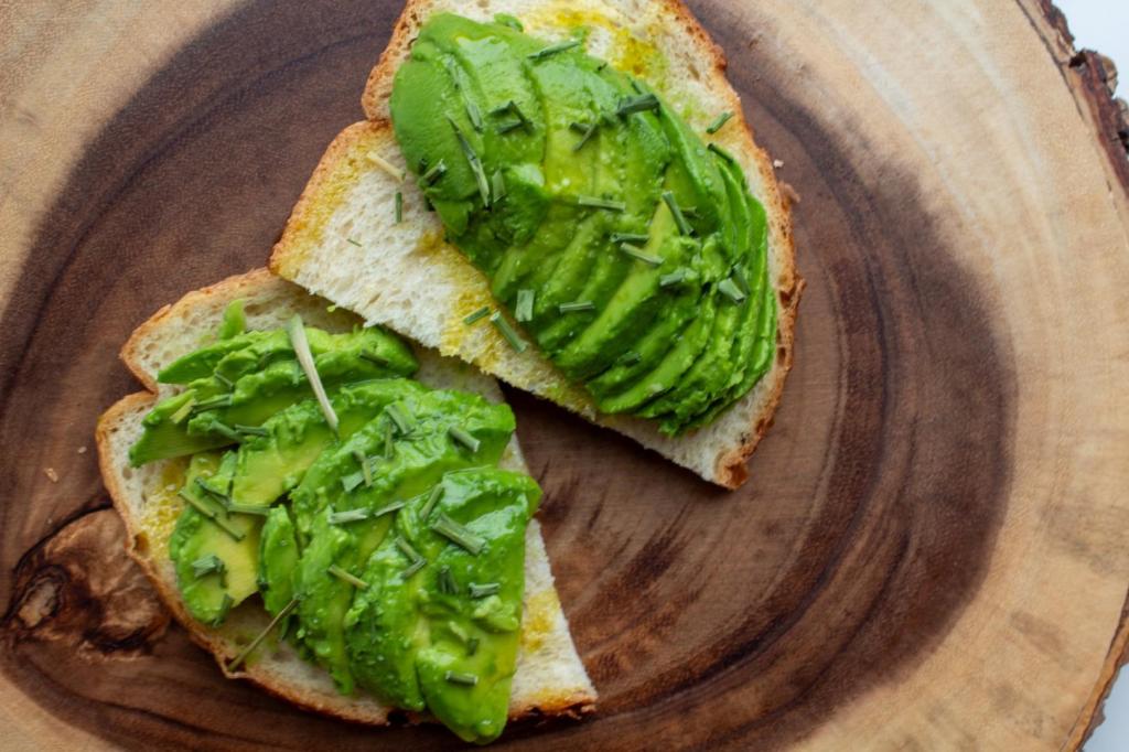 Avocado toast toppings include chives, olive oil, salt, and lime juice all on top of avocado toast.
