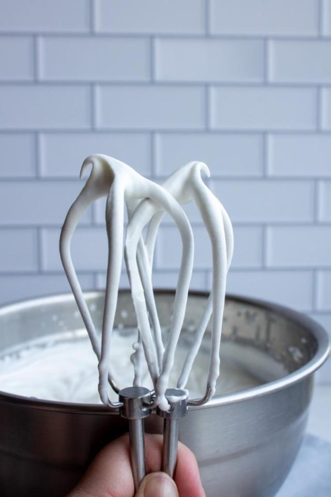 Whipped cream peaks are shown on mixer paddles.