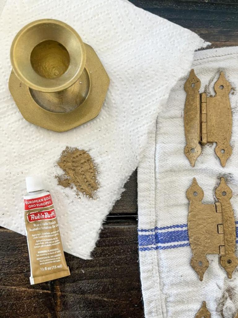 Rub n Buff European Gold is shown being applied to old cabinet hinges.