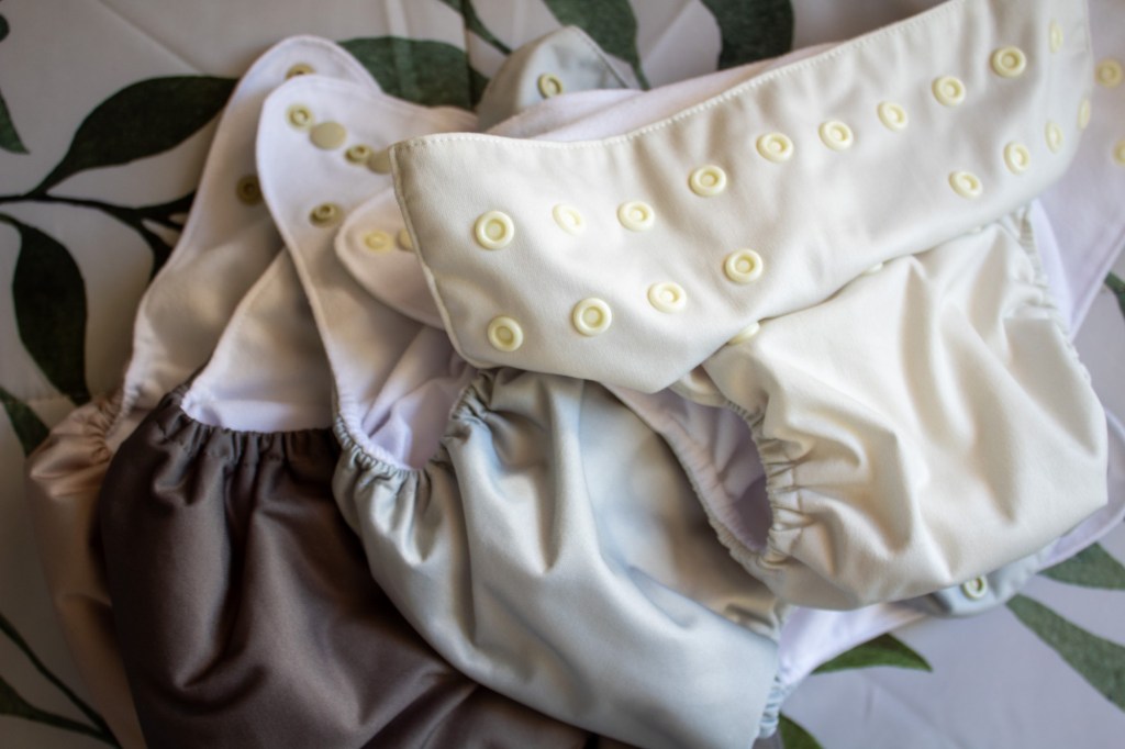 Several light toned Nora's nursery cloth diapers are shown for a review.