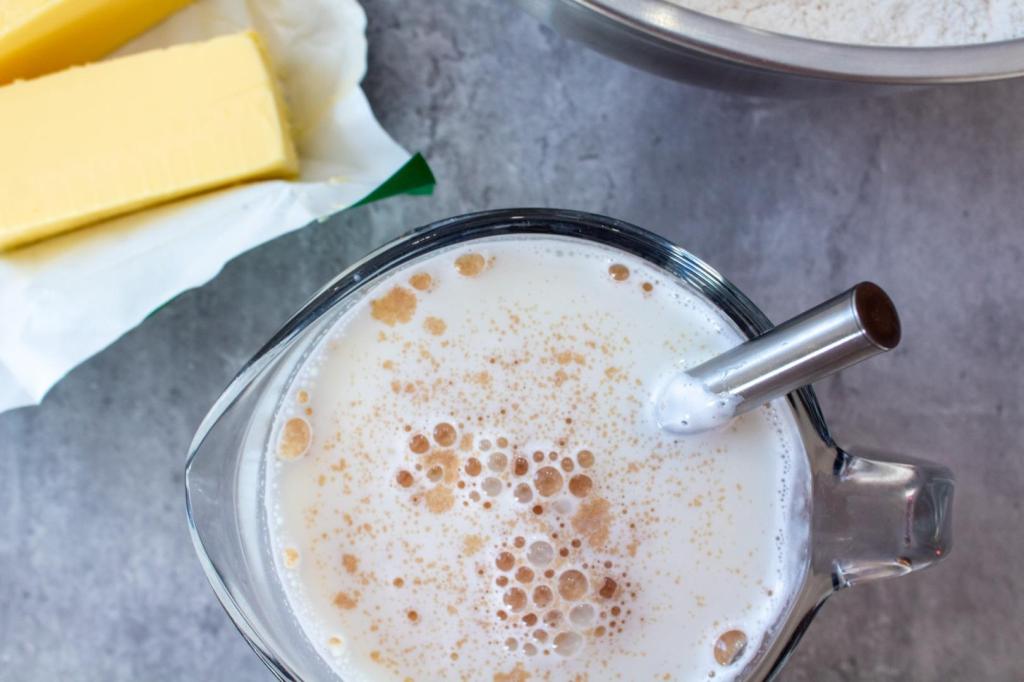 Yeast has been added to warm milk and sugar in a liquid measuring cup.