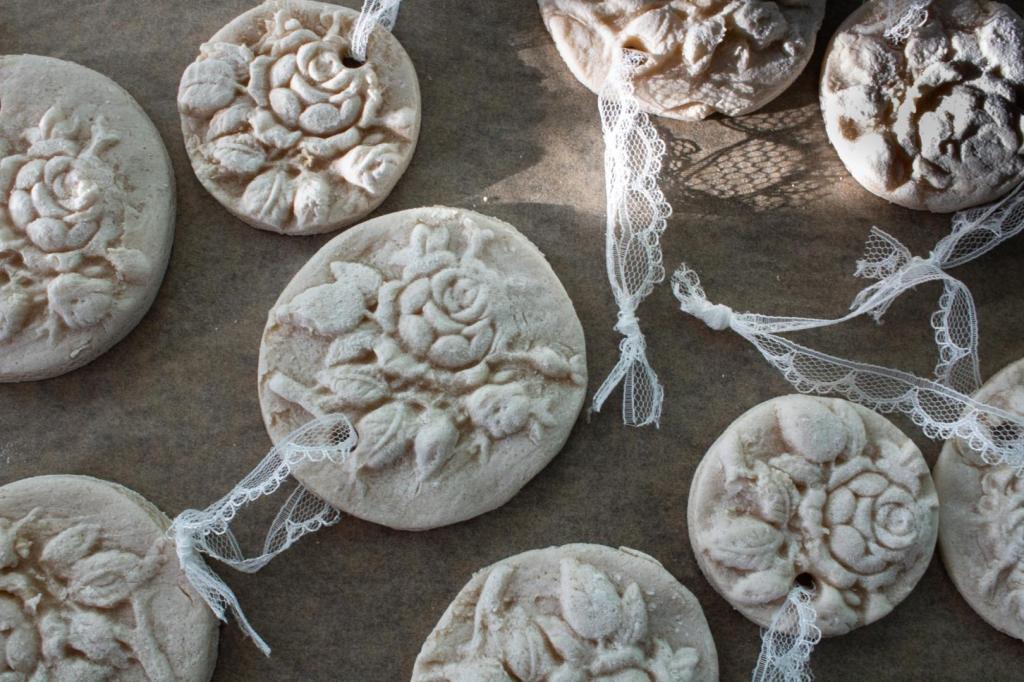 Cottagecore Christmas ornaments are spread out after having ribbon added to them.