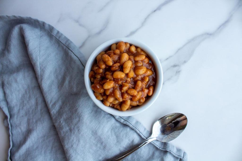 Vegetarian baked beans are served next to a linen and a spoon.