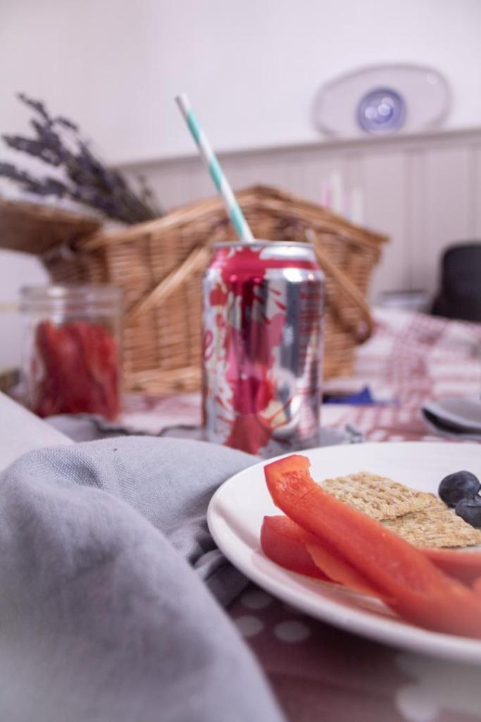 A picnic spread is scattered about on a dining room table on a rainy day.