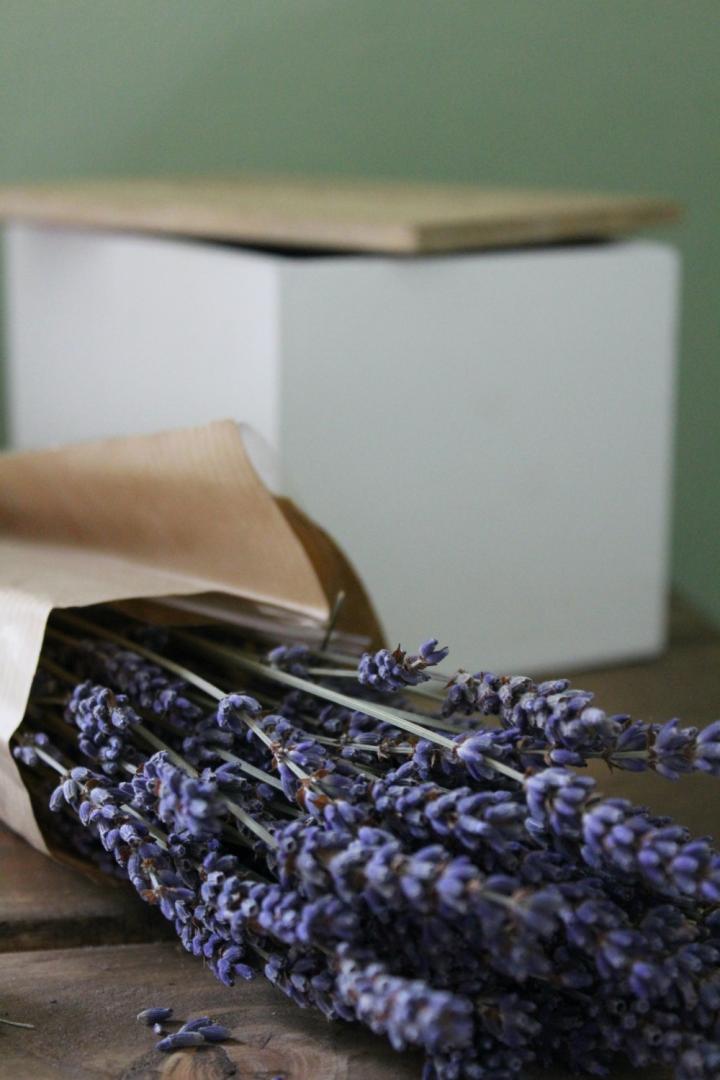 A lavender bouquet is in front of a white box on a side table for summer decorating ideas.
